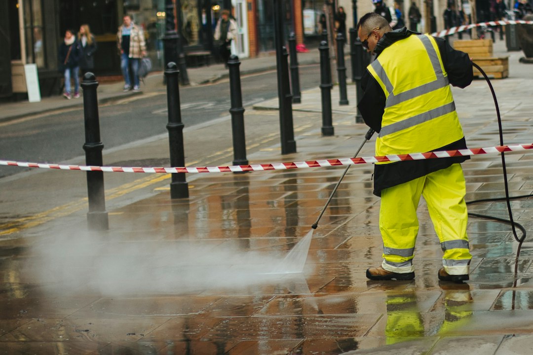 Lavage à pression d'un trottoir devant un commerce