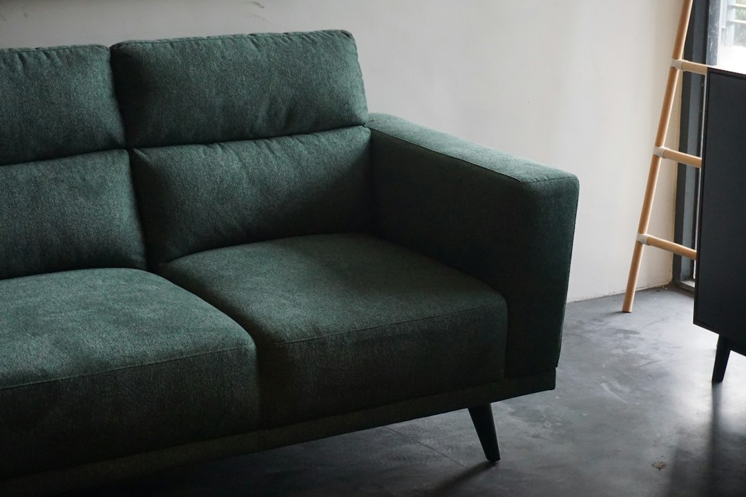 Un professionnel nettoie un canapé en tissu.