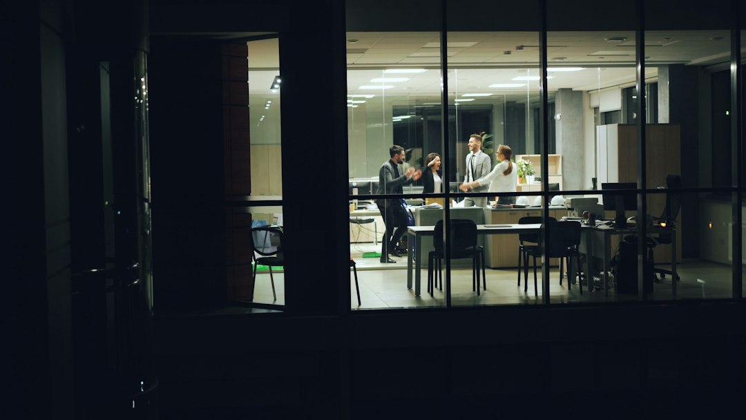 Une équipe d'entretien traverse le hall d'une tour de bureaux, de nuit